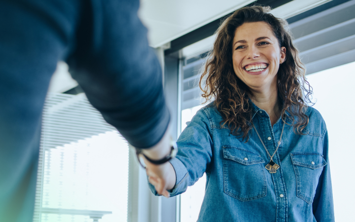 A  woman is meeting and shaking hand with a local super expert