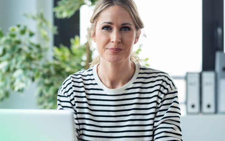 A women is sitting in front of her laptop