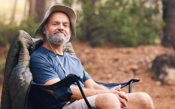 A happy man sitting on a camping chair