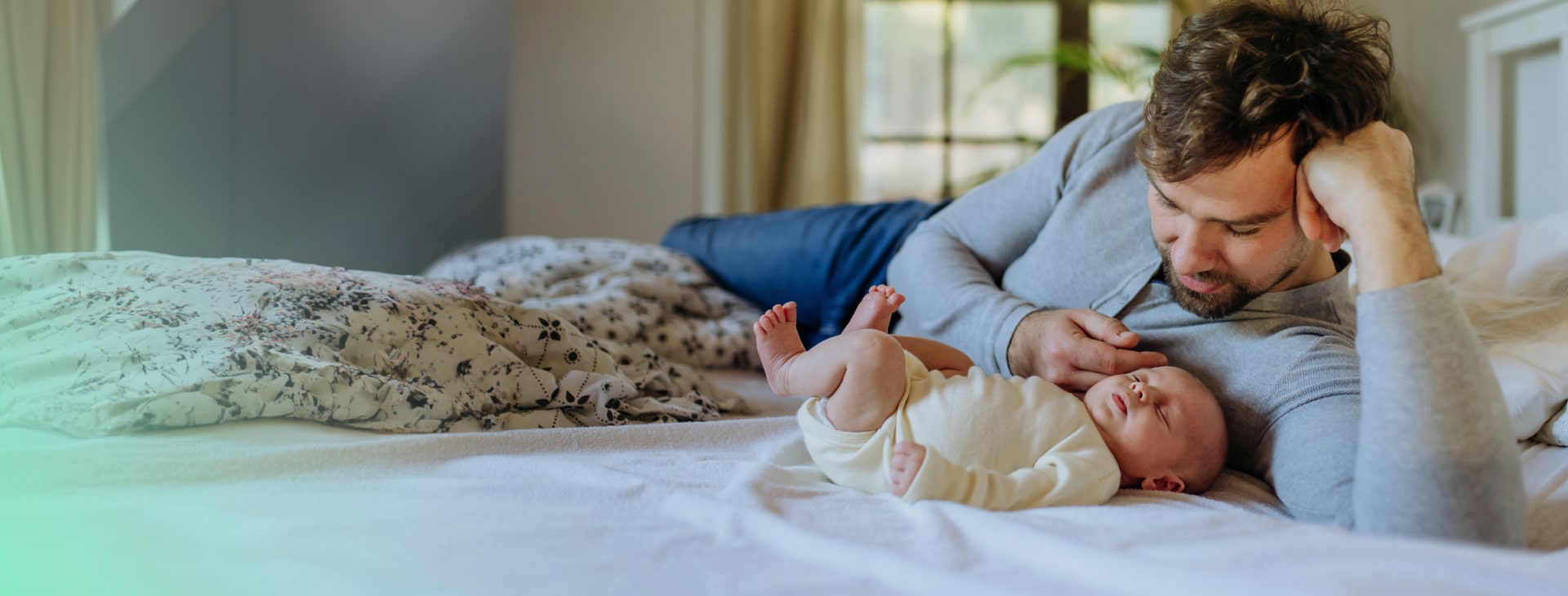 a dad is looking after a sleeping newborn baby
