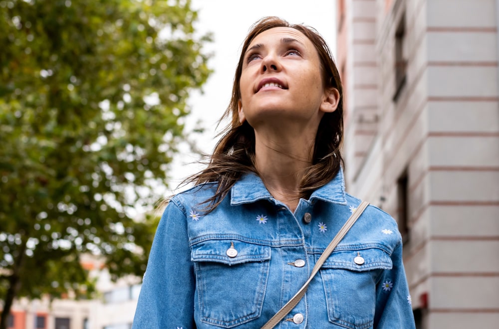 a woman is looking up the sky