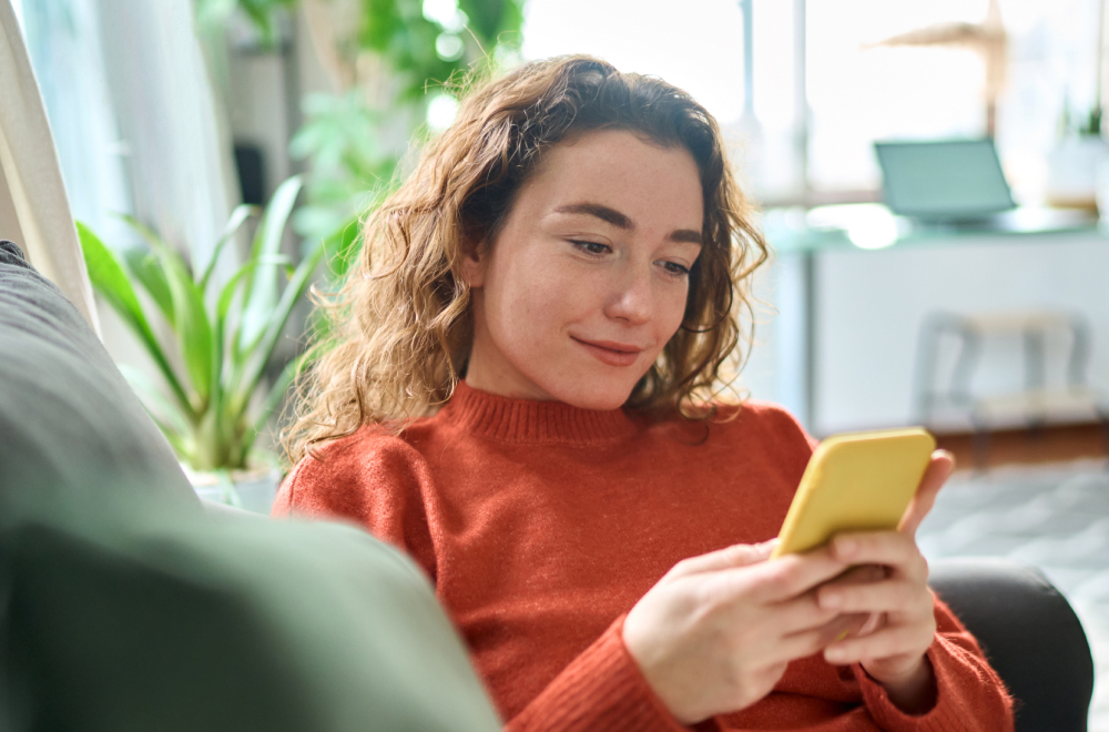 a lady is working on her phone changing her investment