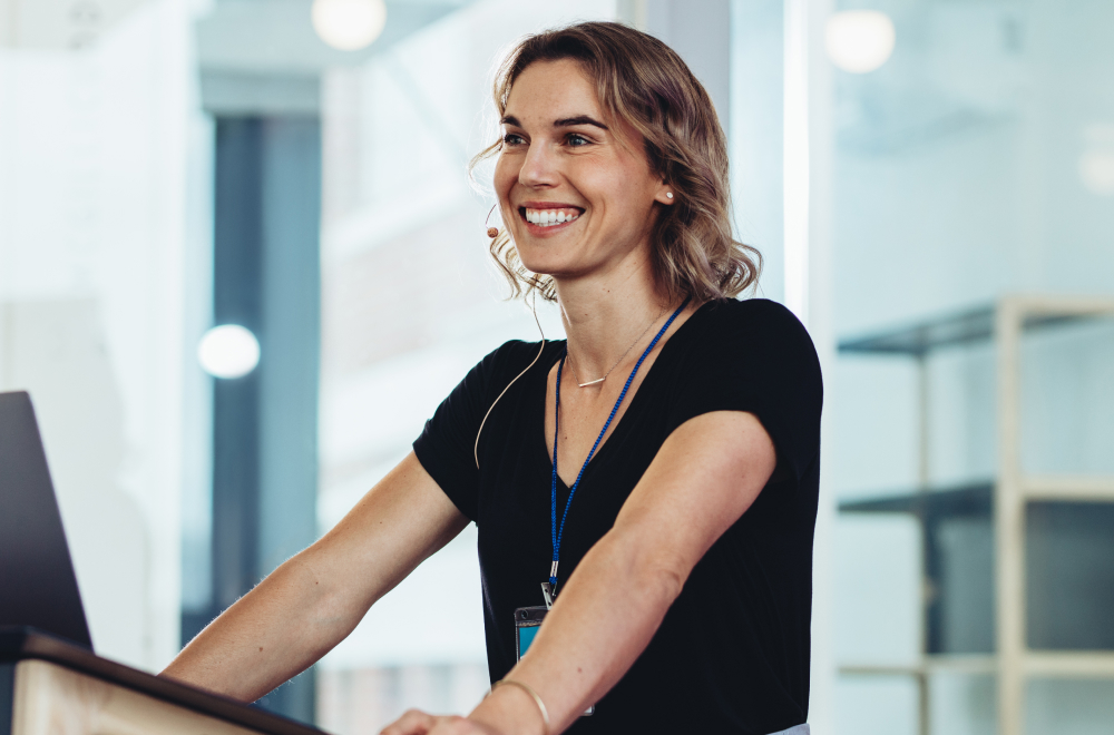 a happy woman is presenting at a seminar