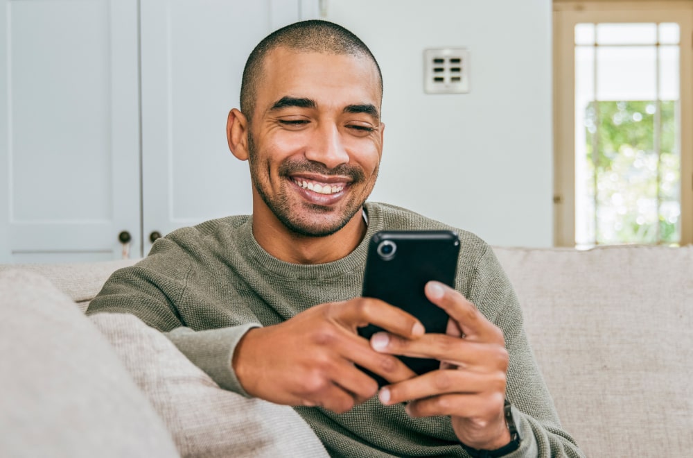 a happy man looking at his phone