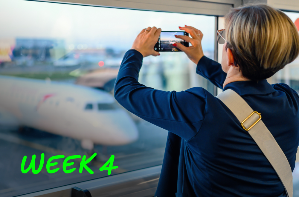 A woman is at the airport and taking a photo of an airplane using her phone