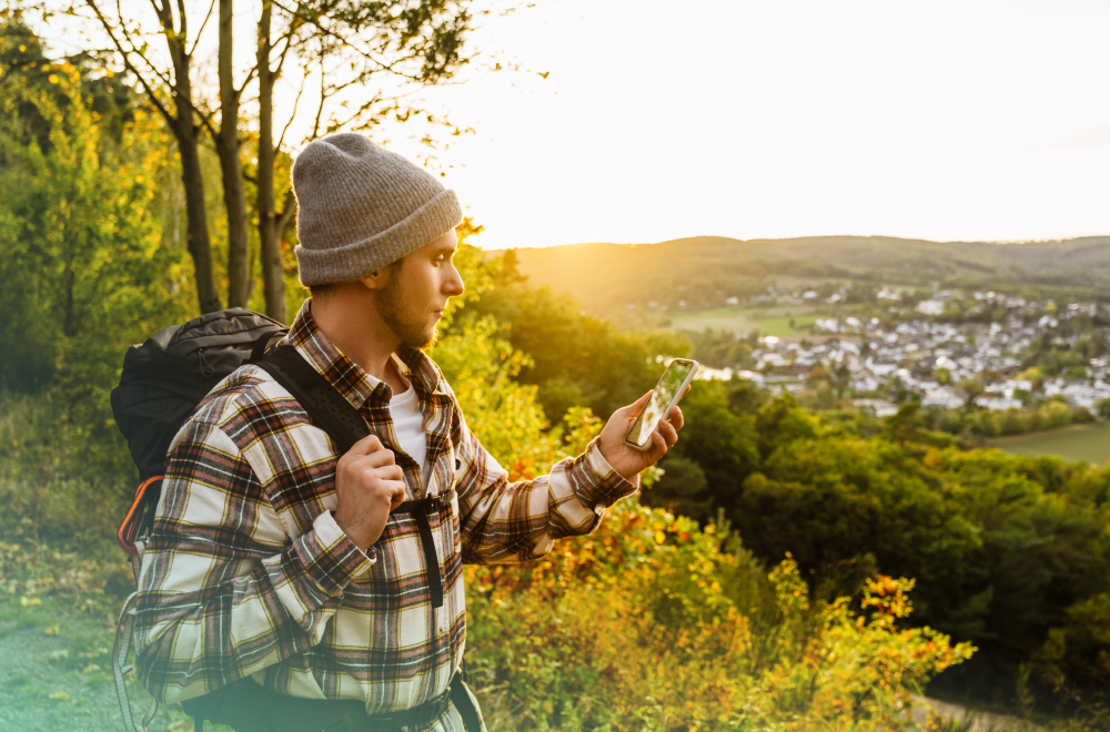 Man standing outside looking down at phone in his hand