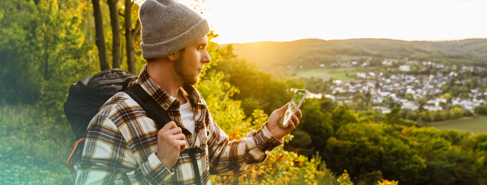 man standing outside looking at phone