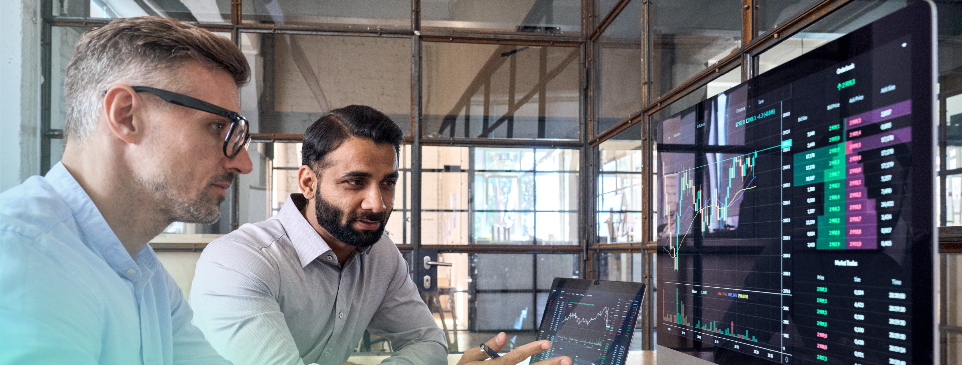 two men looking at a computer screen showing graphs