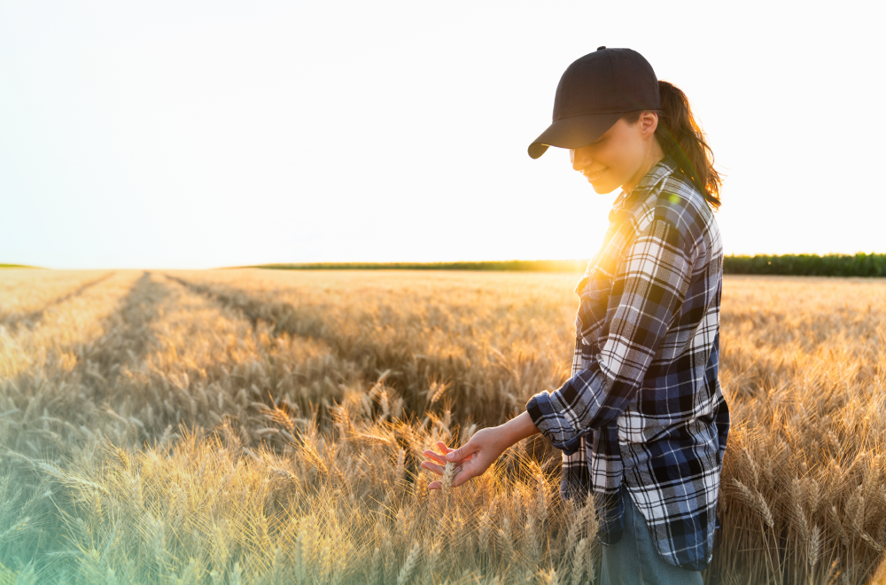 Women in wheat field looking down smiling